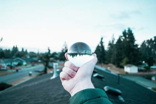 human person holding black glass ball sphere