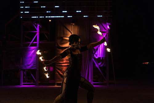 people woman holding fire dancing rod while dancing on stage human