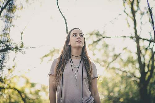 people woman in gray t-shirt standing between tree branches human