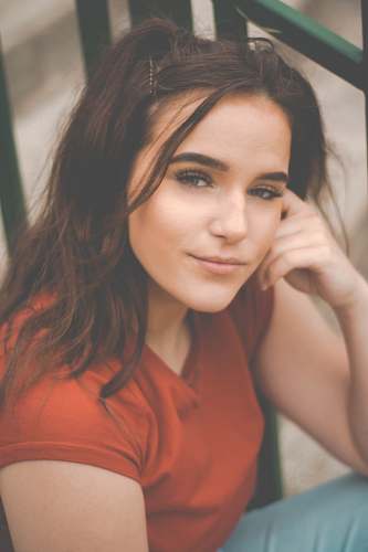 human woman smiling and sitting beside rail face