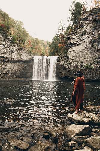 water woman standing near waterfalls nature