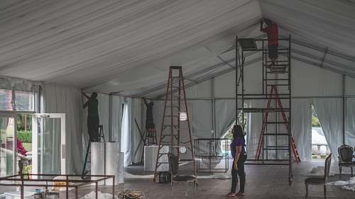 human woman supervising a group of men decorating people