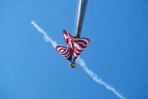 human worm's-eye view photography of USA flag in pole people