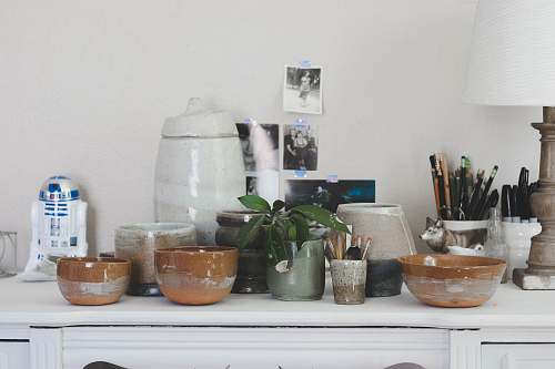 pottery brown ceramic bowl on white wooden sideboard pot
