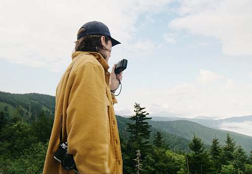 tree man wearing yellow coat with camera human