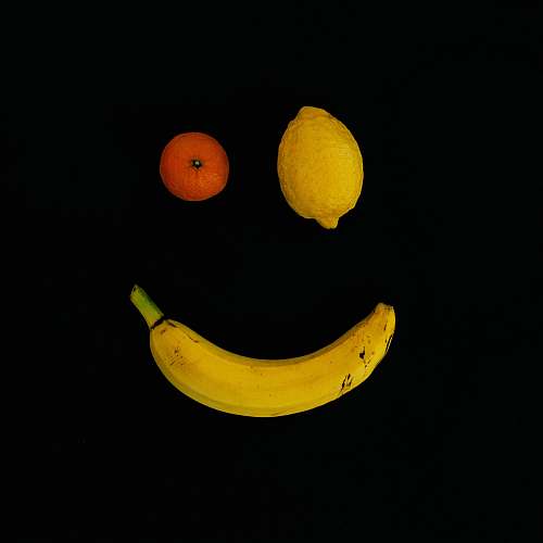 food yellow lime, orange fruit, and yellow banana with smile formation fruit