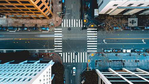intersection bird's eye photography of vehicles on road near building structures asphalt