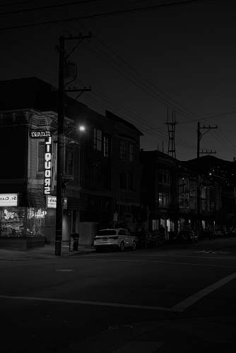 black-and-white grayscale photo of white car park beside road intersection