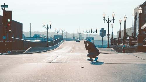 downtown man squatting on road while taking photo dubuque