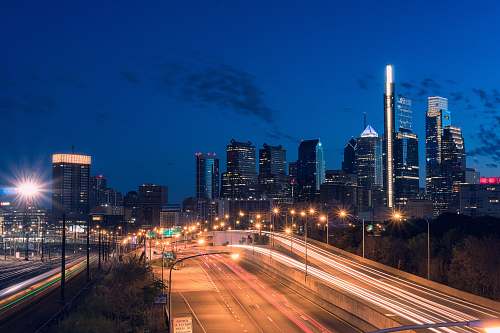 highway timelapse photography of street and high-rise buildings freeway
