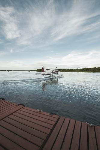 transportation white and red airplane taking off from water seaplane