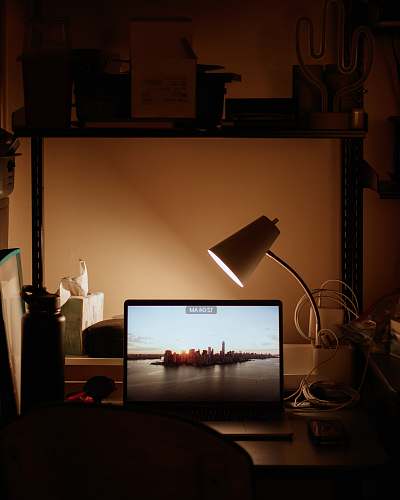 display laptop turned on beside desk lamp turned on electronics