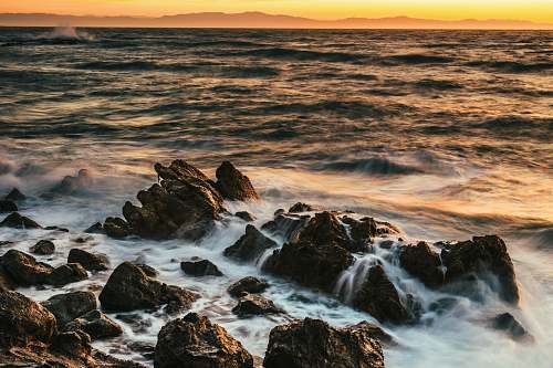 ocean rock on beach under golden hour nature