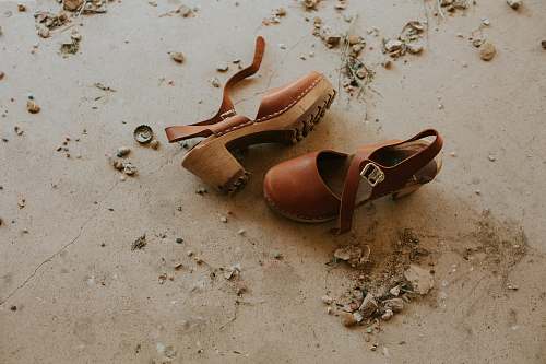 clogs pair of brown ankle-strap sandals on floor footwear