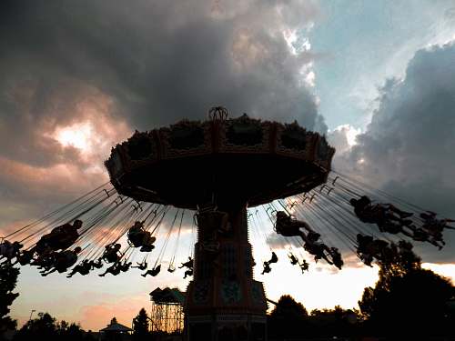 fountain beige carousel under cumulud clouds water