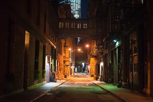 urban empty street in between of buildings during nighttime building