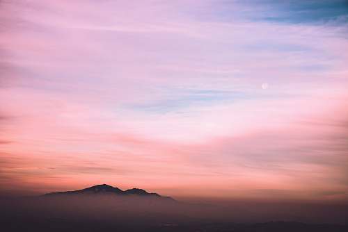 sunset black mountain under blue and white sky nature
