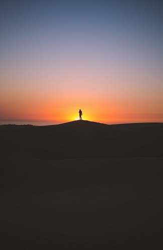 sunset silhouette of person standing on hill sky