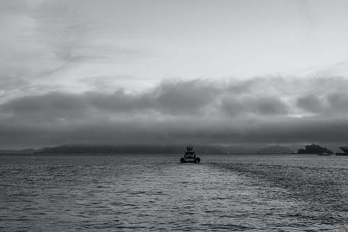 black-and-white grayscale photo of boat on ocean boat