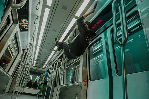 train man hanging on black rope vehicle
