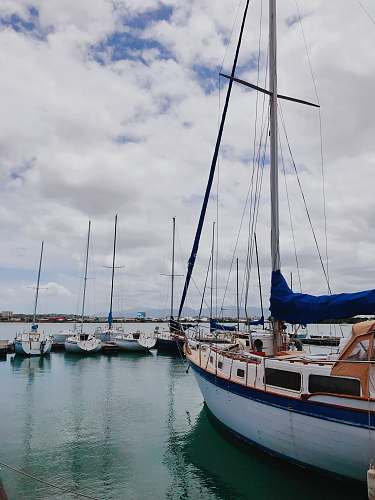 vehicle white and blue boat on sea under white clouds during daytime boat