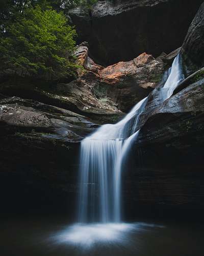 river waterfalls near green-leafed tree waterfall