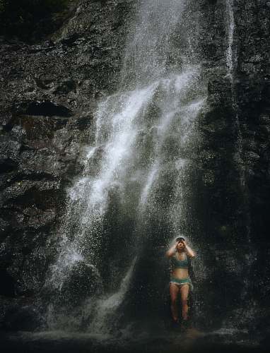 grey woman taking a bath in waterfalls ka‘au crater