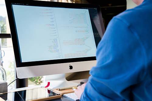 technology person facing monitor while typing during daytime computer