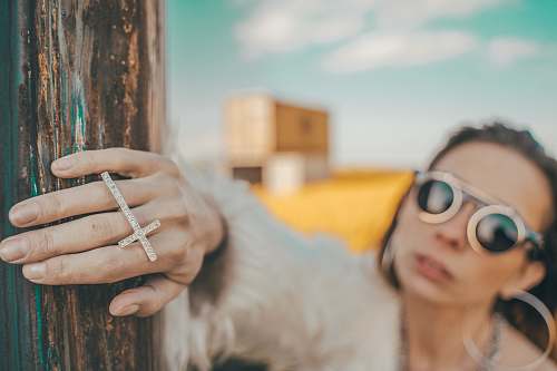 accessories selective focus photography of woman wearing gold-colored cross ring sunglasses