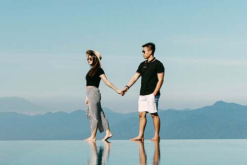 clothing man and woman walking near mountains shorts
