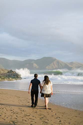 clothing man and woman walking together on seashore shorts