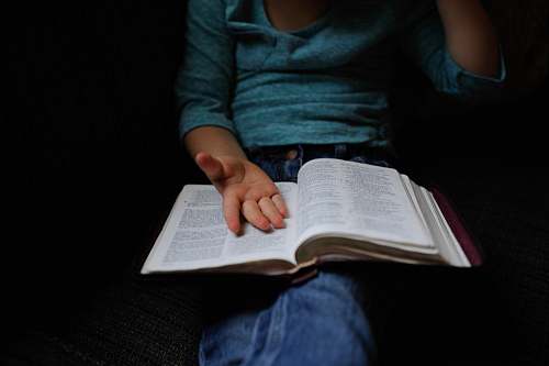 book person wearing blue long-sleeved shirt reading book reading