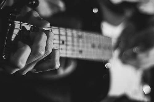 music grayscale photo of person playing guitar guitar