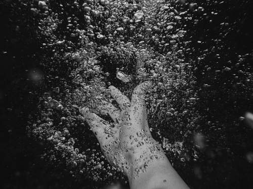 black person's arm under water with frizz water