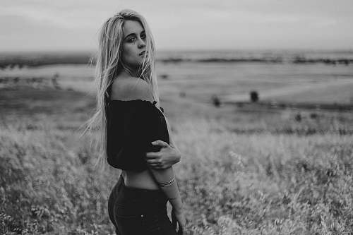 woman woman in black off-shoulder crop-top standing on grass field girl