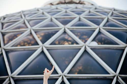 architecture closeup photo of person pointing glass roof dome