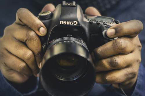 canon person holding DSLR camera dslr