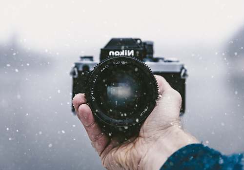 nikon person holding Nikon DSLR camera snowfall