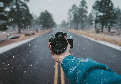 road person holding Nikon DSLR camera person