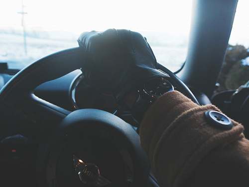 cushion person holding black steering wheel grey
