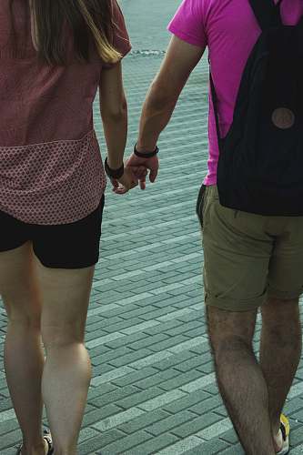 apparel man and woman holding hands while walking shorts