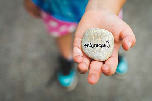 holding person holding stone with cooperative text stone