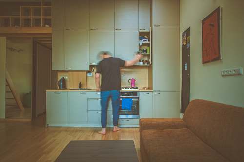 kitchen man facing on gray wooden cabinet picking container room