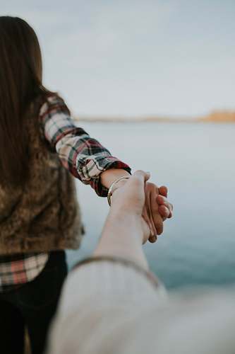 people shallow focus photography of man and woman holding hands woman
