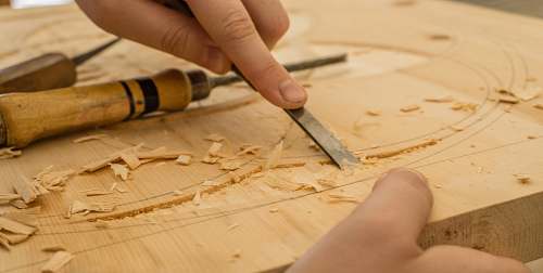 wood person using chisel while curving wood crafting