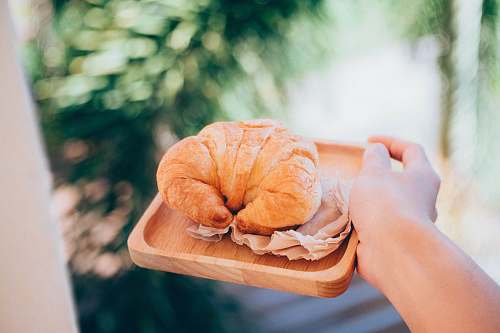 pastry croissant on wooden plate holding