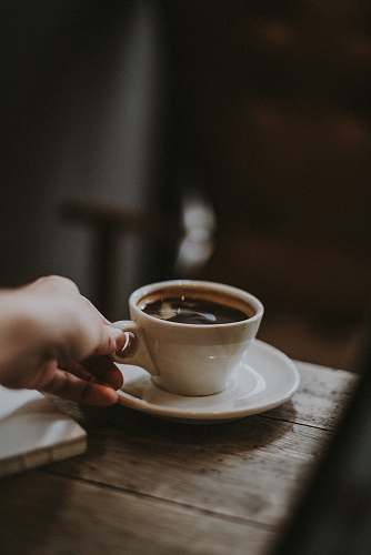 coffee person holding white ceramic cup with liquid coffee cup
