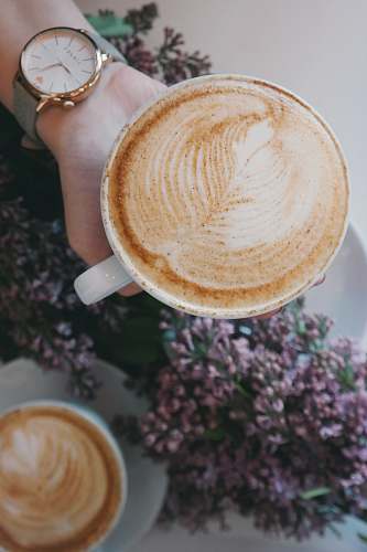 coffee person holding white ceramic espresso cup froth