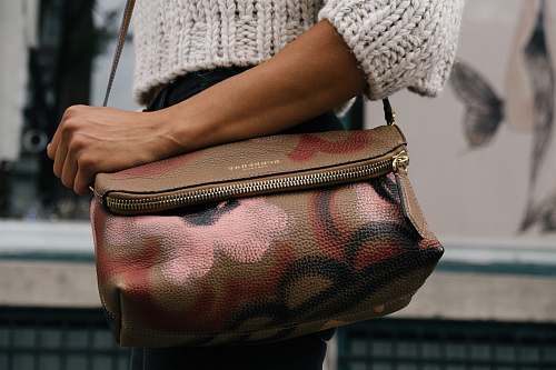 trend woman holding brown and pink floral leather crossbody bag handbag