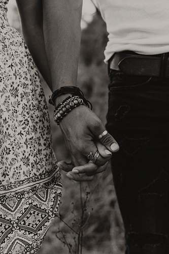 person gray-scale photo of woman and man holding hands human